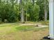 Spacious backyard featuring a green lawn, mature trees, and a view of the surrounding woods at 2018 Quiet Ibis Rd, Hanahan, SC 29410