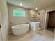 Serene bathroom with freestanding tub, tiled shower, and a window providing natural light and wooded views at 2018 Quiet Ibis Rd, Hanahan, SC 29410