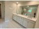 Modern bathroom features double vanity with white cabinets, quartz countertop, large mirror and tile floors at 2018 Quiet Ibis Rd, Hanahan, SC 29410