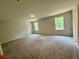 Sunlit bedroom boasts neutral carpet, recessed lighting, and two large windows overlooking a green landscape at 2018 Quiet Ibis Rd, Hanahan, SC 29410