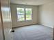 Bright bedroom features a plush gray carpet and two windows overlooking a residential neighborhood at 2018 Quiet Ibis Rd, Hanahan, SC 29410