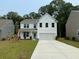 Charming two-story home with white siding, an attached two-car garage, and a freshly poured concrete driveway at 2018 Quiet Ibis Rd, Hanahan, SC 29410