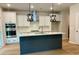 Modern kitchen with a large island, stainless steel appliances, white cabinets, and stylish pendant lights at 2018 Quiet Ibis Rd, Hanahan, SC 29410