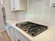 Close up of new stainless steel stove with stainless steel knobs on a quartz countertop with white cabinets and white subway tiles at 2018 Quiet Ibis Rd, Hanahan, SC 29410