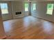 Large living room featuring hardwood floors, a modern fireplace, and lots of natural light from three windows at 2018 Quiet Ibis Rd, Hanahan, SC 29410