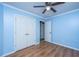 Bedroom with blue walls, hardwood flooring, a window, ceiling fan, closet, and white trim at 2031 Thornhill Dr, Summerville, SC 29485