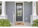 Inviting front door with glass window and welcome mat, framed by elegant columns at 208 Kirkland St, Goose Creek, SC 29445