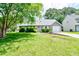 Charming single-story home featuring a well-manicured lawn, lush landscaping, and inviting curb appeal at 209 Apache Dr, Summerville, SC 29483