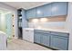 Laundry room with blue cabinets, white counters, modern appliances and tile flooring at 209 Apache Dr, Summerville, SC 29483