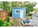 Blue shed with white trim, with visible pool equipment, surrounded by landscaping at 209 Apache Dr, Summerville, SC 29483