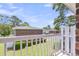 Sunny balcony view with white picket fence overlooking well-manicured lawn and mature trees at 21 Rivers Point Row # 17G, Charleston, SC 29412