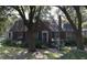 Charming brick home featuring a well-manicured lawn and mature trees providing shade at 218 Yates Ave, Charleston, SC 29412