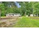 View of house in a backyard with mature trees, green grass and utility sheds at 2202 Sc-61, Ridgeville, SC 29472