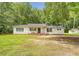 Charming single-story home featuring a covered front porch, black shutters, and mature trees at 2202 Sc-61, Ridgeville, SC 29472