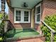 Inviting front porch featuring a vintage fan, an artificial turf rug, and decorative brickwork at 2204 Dover St, North Charleston, SC 29405