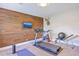 This stylish exercise room boasts a treadmill, mounted TV, and wood-accent wall for a modern workout space at 2336 Brinkley Rd, Johns Island, SC 29455