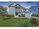 Charming two-story home featuring a double porch, blue siding, well-manicured lawn, and an attached two-car garage at 2336 Brinkley Rd, Johns Island, SC 29455
