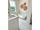 Bright bathroom featuring a standalone tub, white cabinets, and a large window at 25 Nats Ct, Charleston, SC 29403