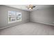 Bedroom with neutral walls, ceiling fan, carpet floors, and two windows showing neighborhood views at 251 Emerald Isle Dr, Moncks Corner, SC 29461