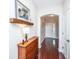 Hallway with hardwood floors leads past wooden cabinet beneath painting, past entry door, with a door on the right at 254 Mayfield Dr, Goose Creek, SC 29445
