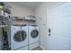 Functional laundry room with a pair of GE washer and dryer units and metal storage shelves at 254 Mayfield Dr, Goose Creek, SC 29445