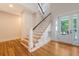 Elegant staircase featuring wood treads, a black handrail, and a view to the entry door at 2701 Fountainhead Way, Mount Pleasant, SC 29466