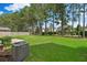 A well-maintained backyard with lush green grass and mature trees lining the fence at 272 Overcup Loop, Summerville, SC 29486
