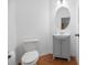 Charming powder room featuring a gray vanity, oval mirror, wood-look floors and toilet at 272 Overcup Loop, Summerville, SC 29486