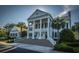 A stately home with pillars and well-manicured landscaping greets you upon arrival, set on a sunny, blue-sky day at 3000 Treadwell St, Mount Pleasant, SC 29466