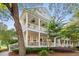 Charming two-story home features double porches, lush landscaping, and inviting curb appeal at 3000 Treadwell St, Mount Pleasant, SC 29466