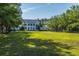 Elegant white home with pillars, a manicured lawn, and shady trees on a sunny day at 3000 Treadwell St, Mount Pleasant, SC 29466