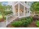 Charming two-story home with a double porch, white railings, and lush landscaping at 3000 Treadwell St, Mount Pleasant, SC 29466