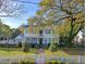 Charming two-story home with a brick walkway, white picket fence, and lush landscaping at 304 Bank St, Mount Pleasant, SC 29464