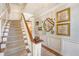 Elegant foyer with a carpeted staircase, chandelier, hardwood floors, and stylish wall decor at 304 Bank St, Mount Pleasant, SC 29464