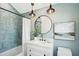 Charming bathroom features blue tile, vanity, round mirror and pendant lighting at 313 E Arctic Ave, Folly Beach, SC 29439