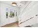 Bright entryway featuring a wood staircase, light hardwood floors, and a glass-paneled door leading to the outside at 313 E Arctic Ave, Folly Beach, SC 29439
