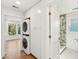 Well-lit laundry area with a stackable washer and dryer, cabinetry, and a peek into a bathroom at 313 E Arctic Ave, Folly Beach, SC 29439
