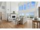 Bright living room with a fireplace, hardwood floors, and a wall of windows overlooking the ocean at 313 E Arctic Ave, Folly Beach, SC 29439