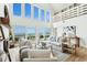 Open living room with floor to ceiling windows showcasing ocean views, light wood floors and white furnishings at 313 E Arctic Ave, Folly Beach, SC 29439