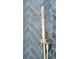 Close-up of a hand-held shower head, brass in color, with blue herringbone tile in the background at 313 E Arctic Ave, Folly Beach, SC 29439