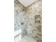 Modern tiled shower with a rainfall showerhead, a built-in niche, and unique tiled walls at 313 E Arctic Ave, Folly Beach, SC 29439
