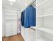 A tidy walk-in closet with wood flooring, multiple shelving units, and rods to hang garments at 313 E Arctic Ave, Folly Beach, SC 29439