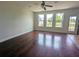 Bright living room featuring gleaming hardwood floors, large windows, and a ceiling fan at 3254 Hartwell St, Johns Island, SC 29455