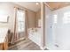 Bright bathroom featuring a tub and a separate glass-enclosed shower, complemented by wood-look flooring at 3290 Middleburry Ln, Charleston, SC 29414