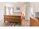 Vaulted ceiling bedroom featuring two windows, wood look floors, king bed, dresser, and open bathroom at 3290 Middleburry Ln, Charleston, SC 29414
