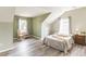 Inviting bedroom with wood-look floors, a sloped ceiling, and two bright windows enhancing the space at 3290 Middleburry Ln, Charleston, SC 29414