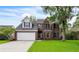 Charming two-story brick home featuring a well-manicured lawn and mature tree, offering classic curb appeal at 3290 Middleburry Ln, Charleston, SC 29414