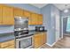 Close up of the kitchen appliances with wood cabinets and a view of the side yard window at 3290 Middleburry Ln, Charleston, SC 29414