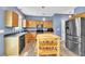 Spacious kitchen with stainless steel appliances, wood cabinets, an island and modern pendant lighting at 3290 Middleburry Ln, Charleston, SC 29414