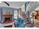 Cozy living room showcasing a brick fireplace, staircase, and view into the kitchen at 3290 Middleburry Ln, Charleston, SC 29414